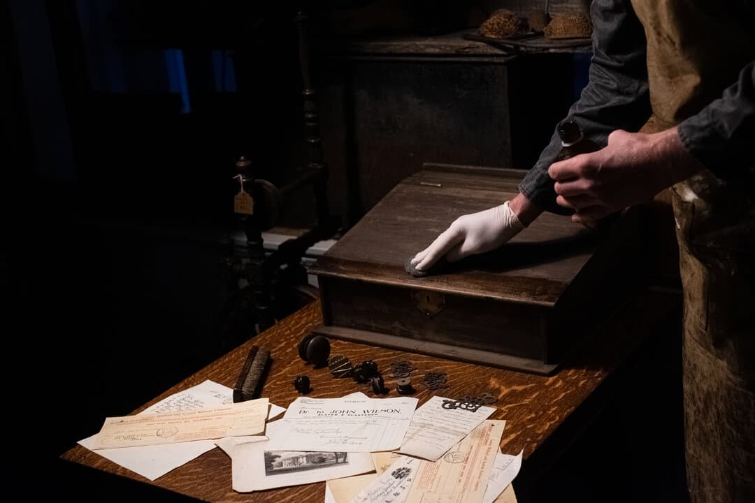 Rob examining antique furniture in the workshop