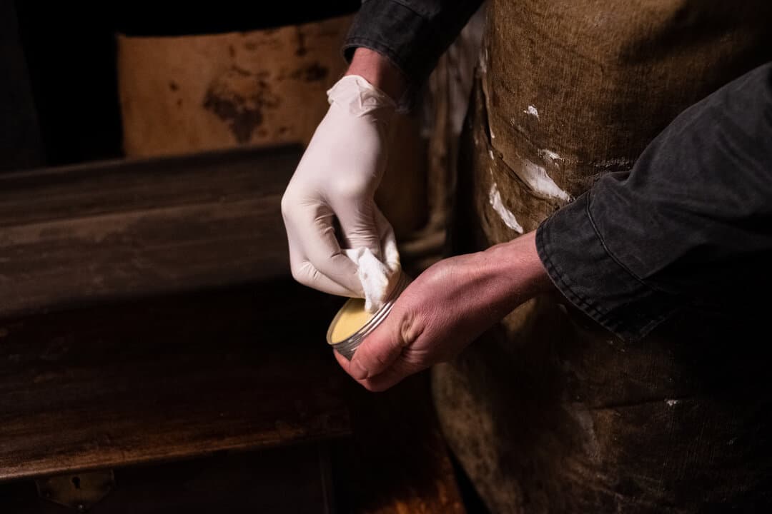 Opening tin of traditional finishing wax