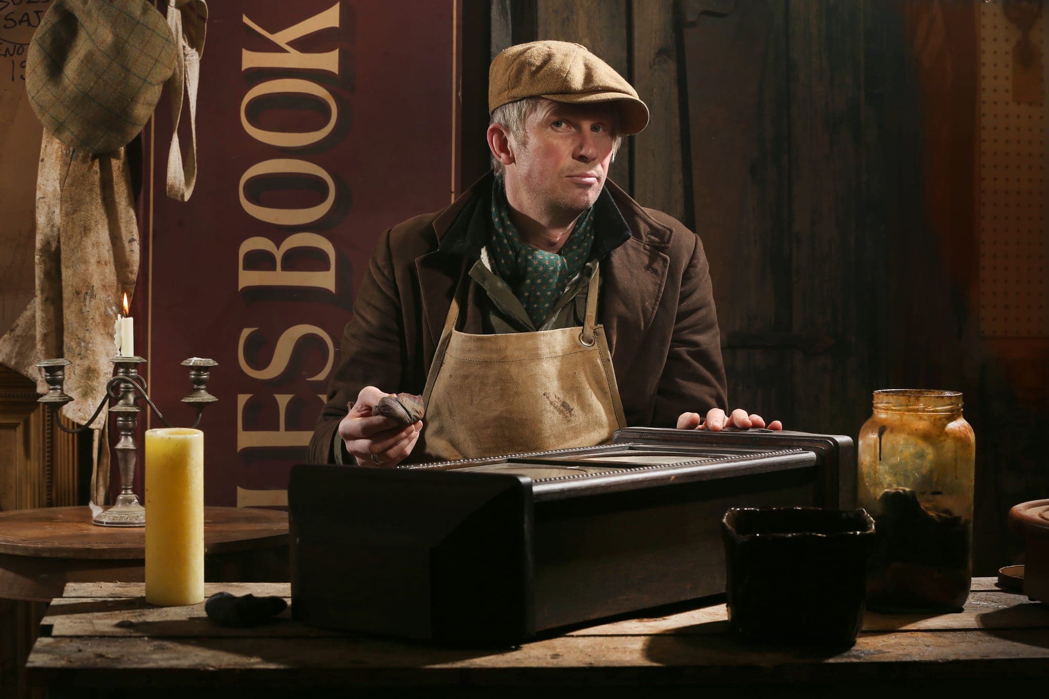 Rob Cain at work in the workshop, examining an antique piece with traditional tools